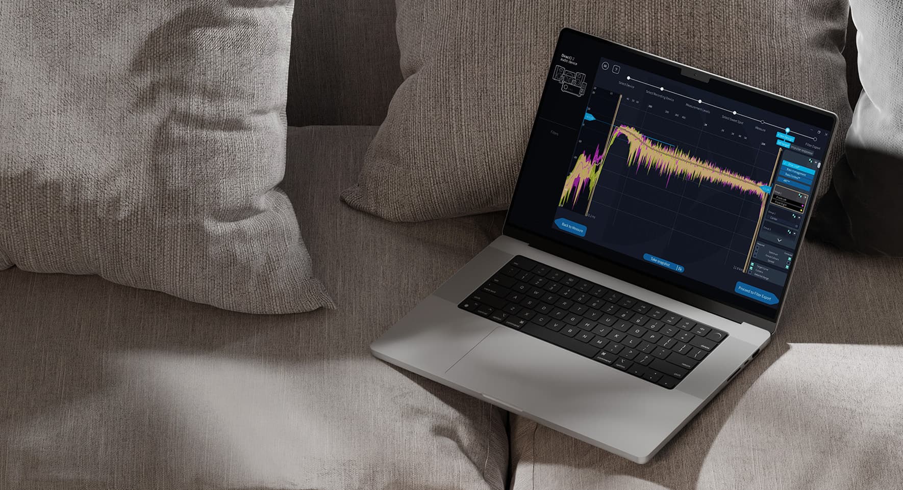 A laptop sitting on a grey sofa with Dirac Live Processor showing on the screen